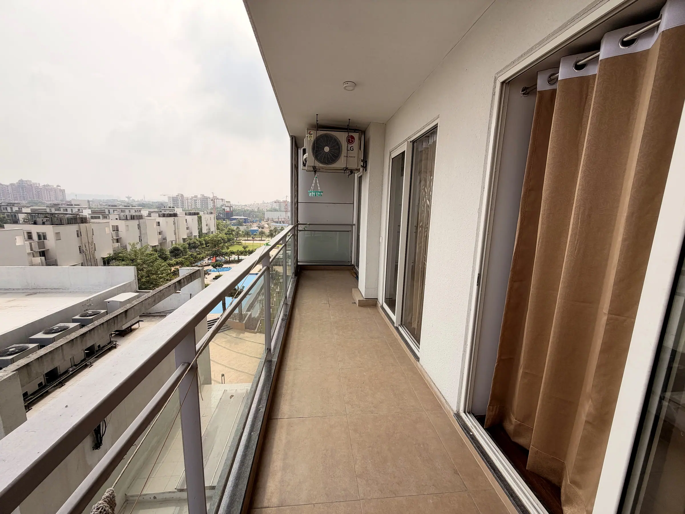 Balcony with a glass railing overlooking the township gardens