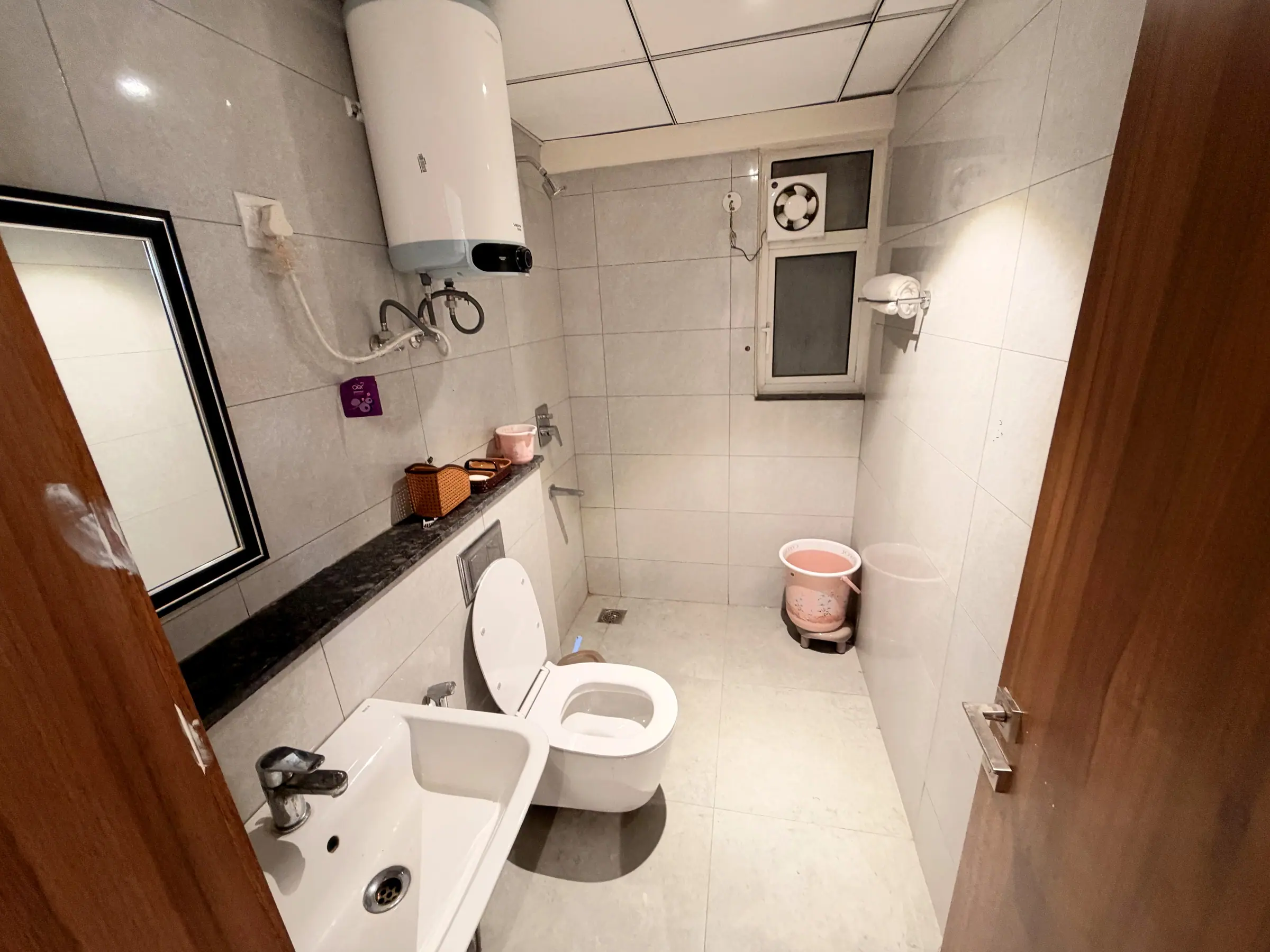 Bathroom one with geyser, wall-hung WC, basin and a granite shelf