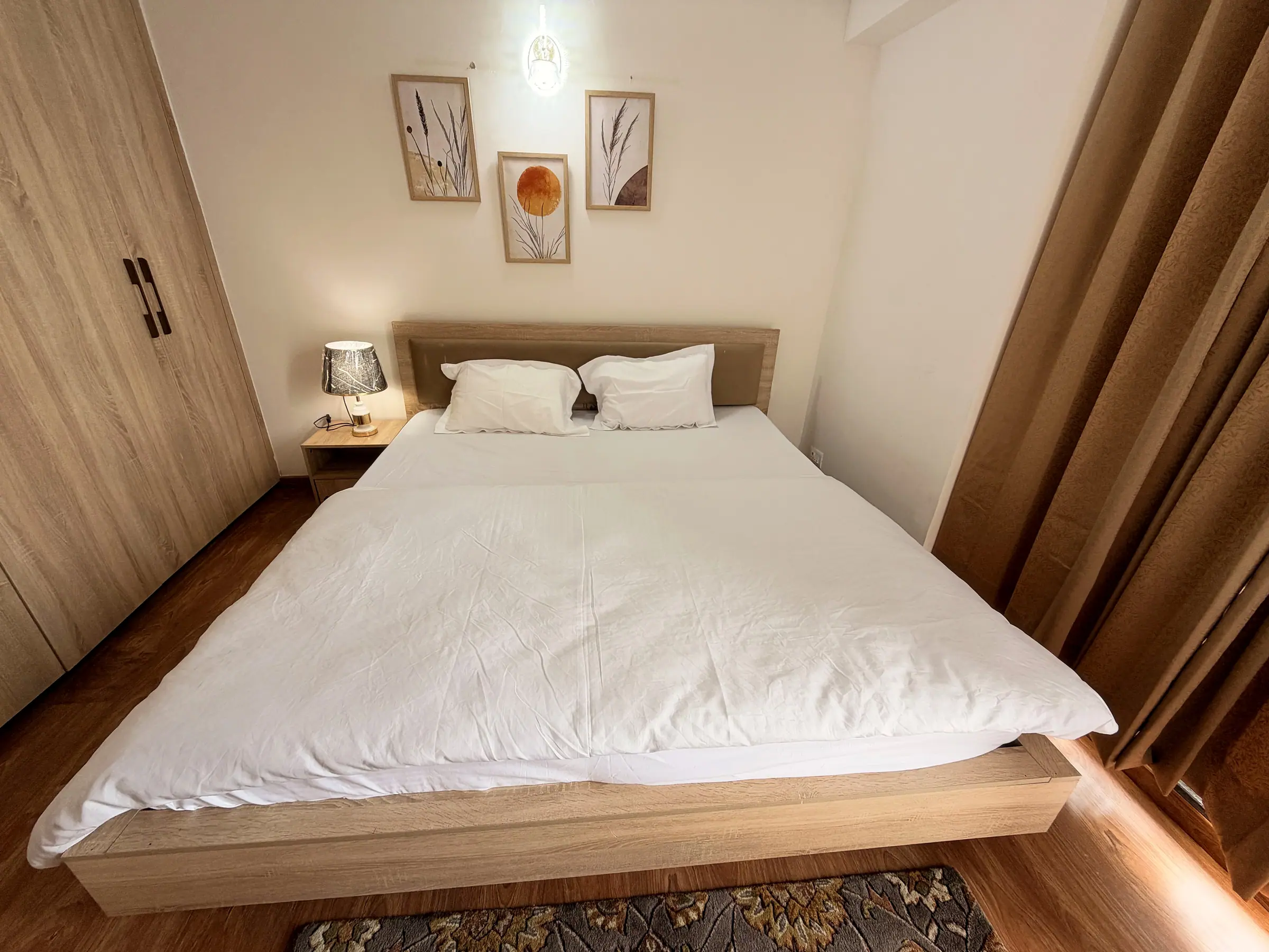 Bedroom one made up with crisp white linen beside a full-height wardrobe