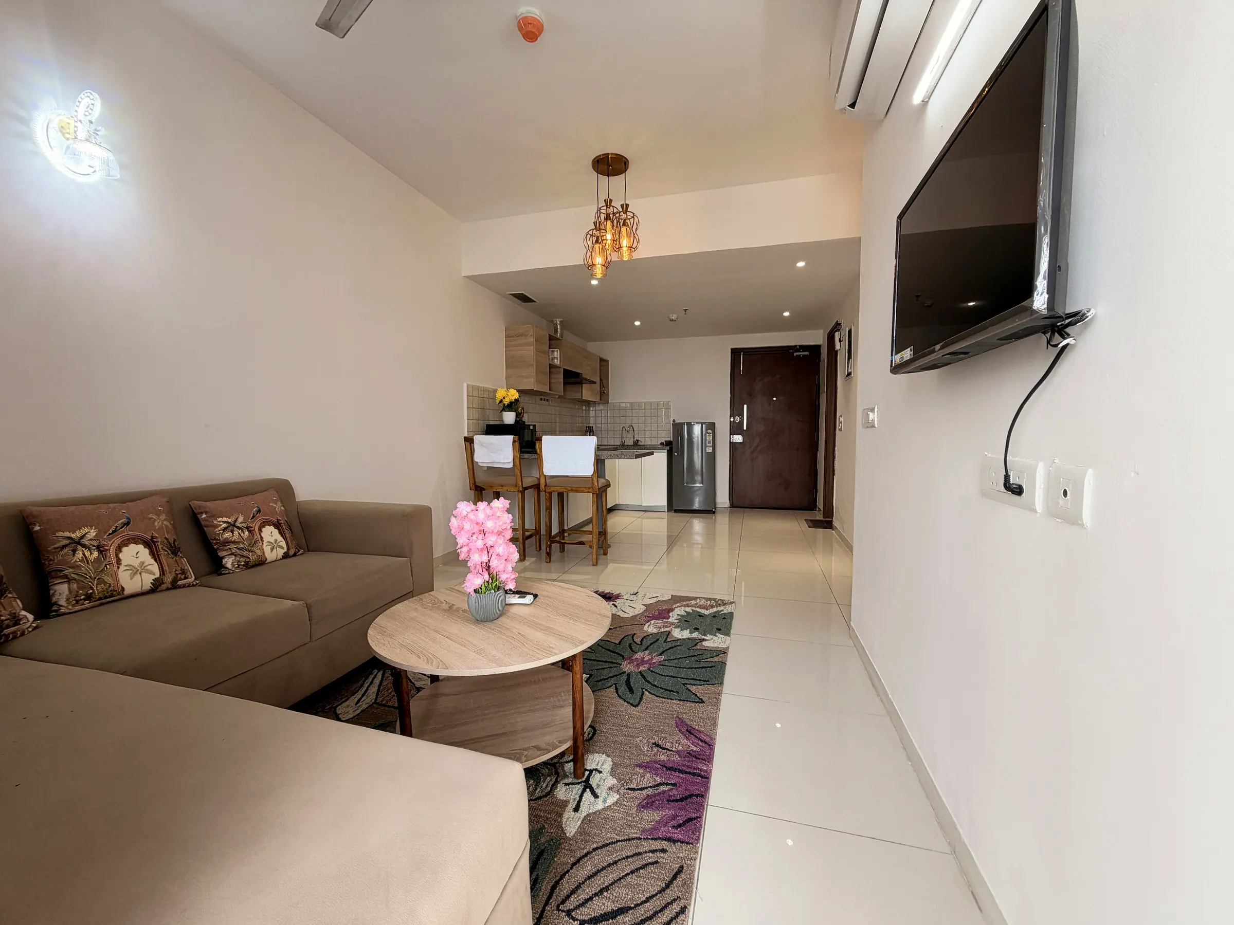 Sofa, coffee table and TV, with the breakfast bar and kitchen beyond