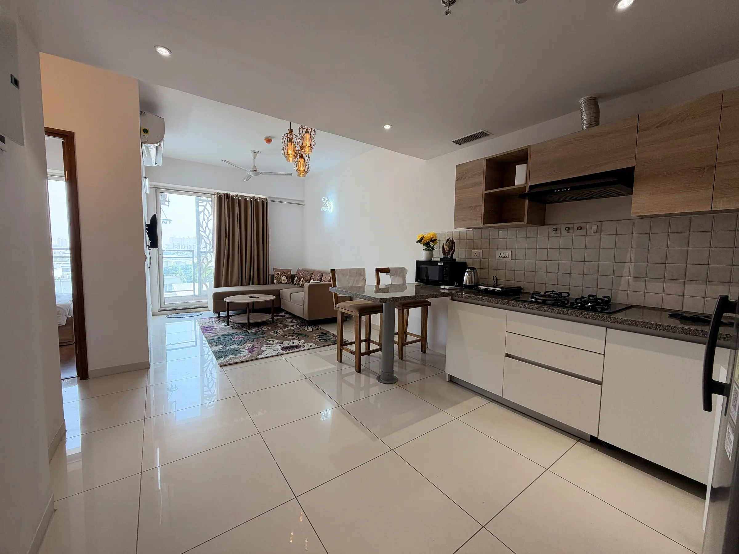 Open-plan kitchen, breakfast bar and living room, with the balcony door at the far end