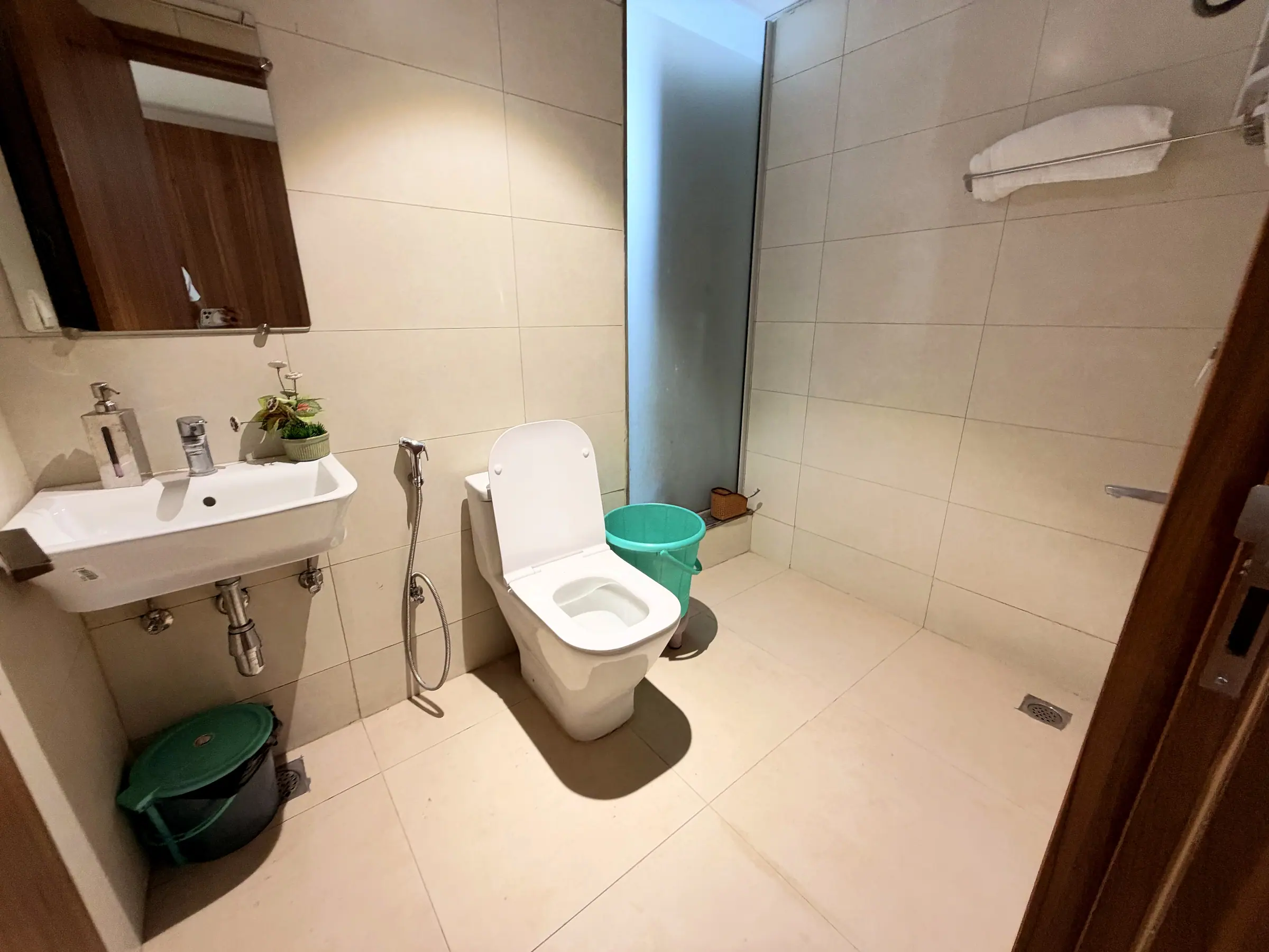 Bathroom with wall-hung basin, WC, health faucet and a frosted-glass shower partition