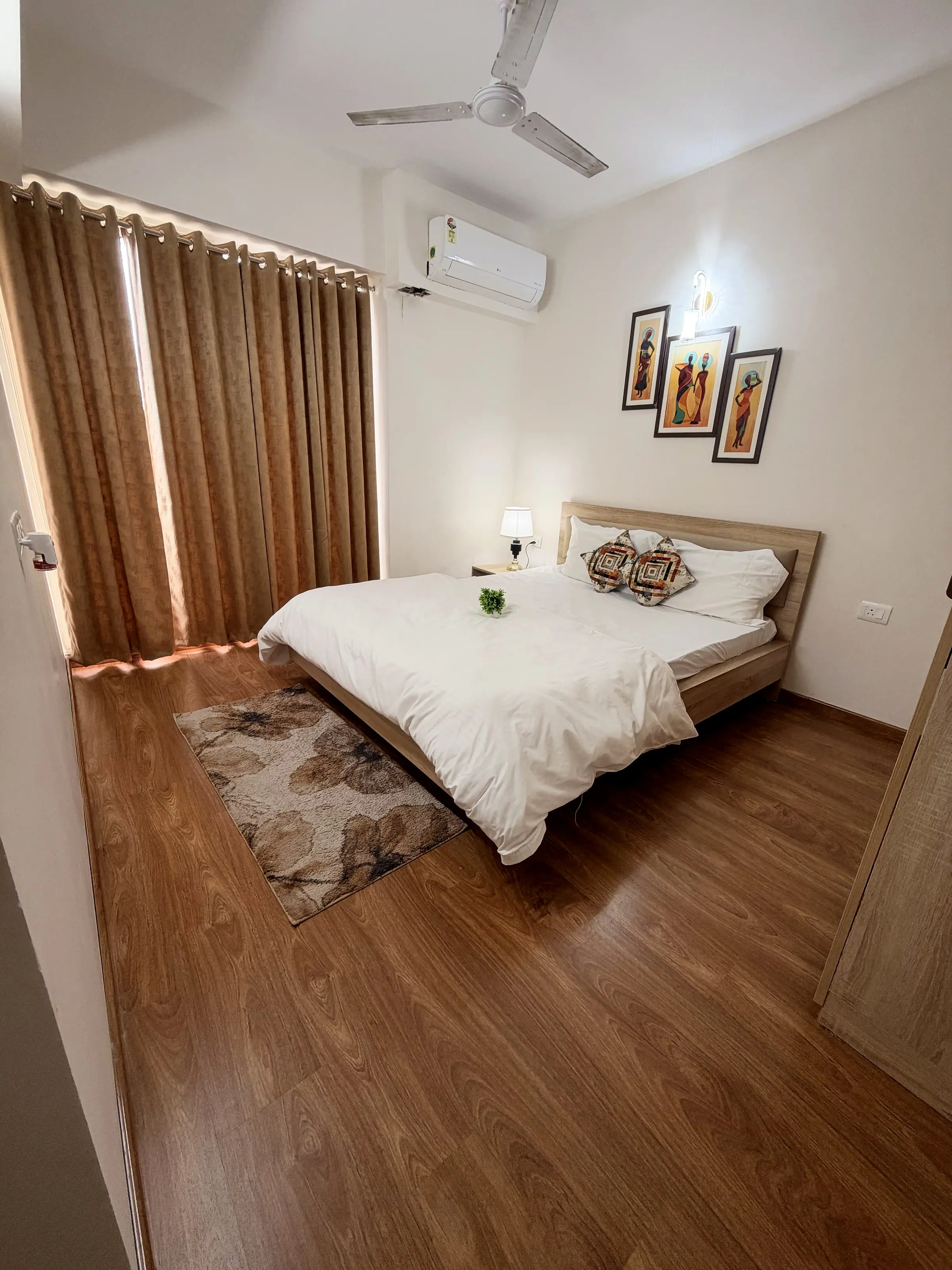 Main bedroom with a floral rug on the wooden floor and a bedside lamp
